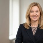 Профессиональный портрет русского бизнесмена, уверенный взгляд, мягкий фон, студийное освещение.