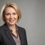 Профессиональный портрет русского бизнесмена, уверенный взгляд, мягкий фон, студийное освещение.